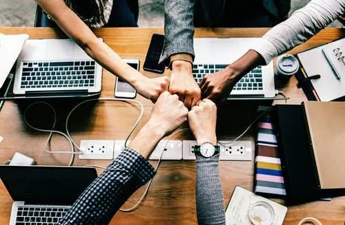 Group of people joining hands in a gesture of support.